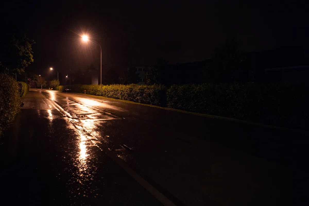 Eine dunkle Strasse mit Strassenlaterne.